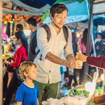 Tourist son buying food in night market Bangkok Listing